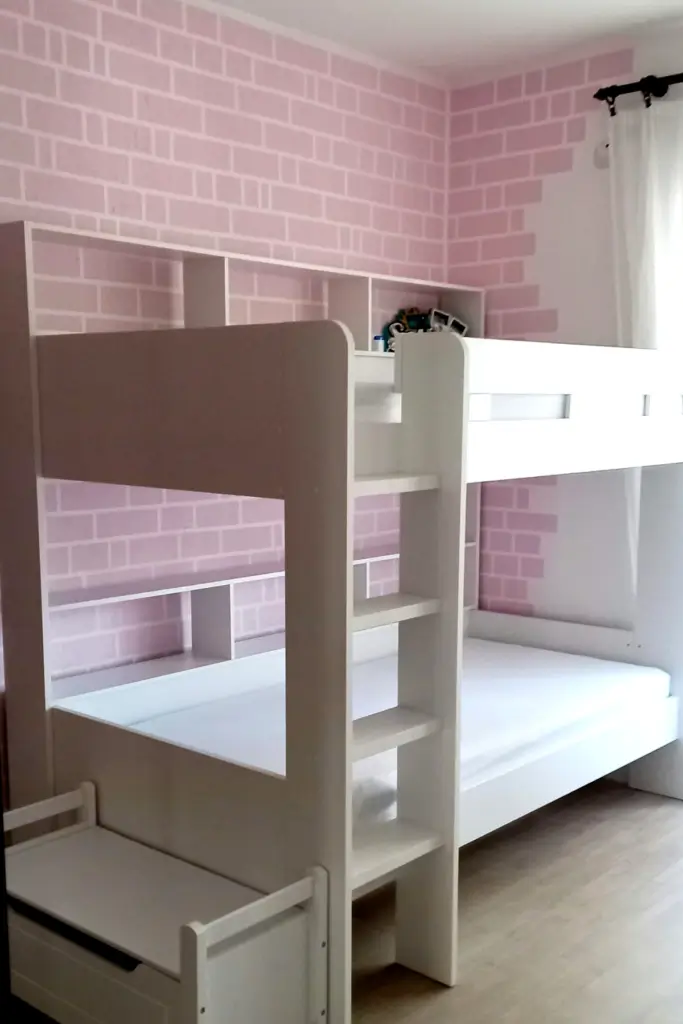 How to Paint Baby Room Wall 7 Modern white bunk bed in kids' room with pink brick accent wall, ladder shelves, and light wood flooring