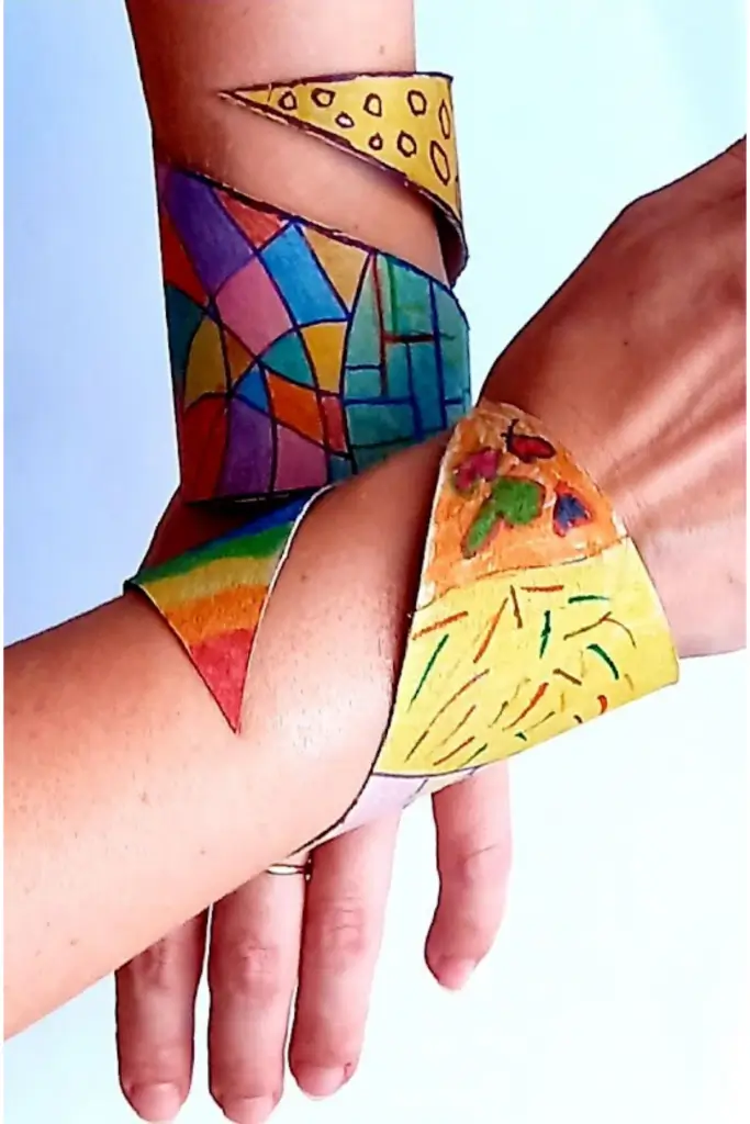 Toilet Paper Roll Bracelets: Crafts for Kids 1 DIY recycled cardboard cuff bracelets on wrists with colorful hand-drawn patterns, kids craft idea.