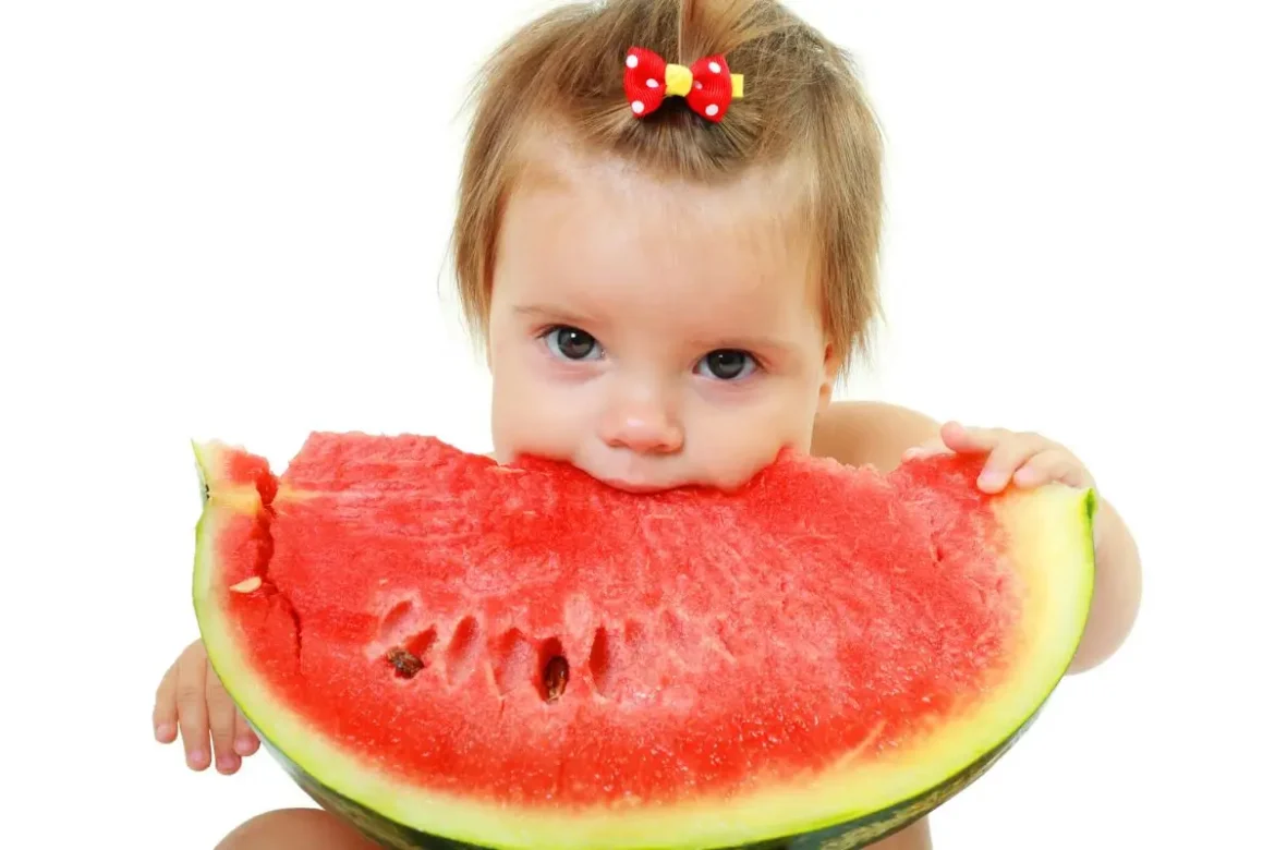 a baby eating a watermellon